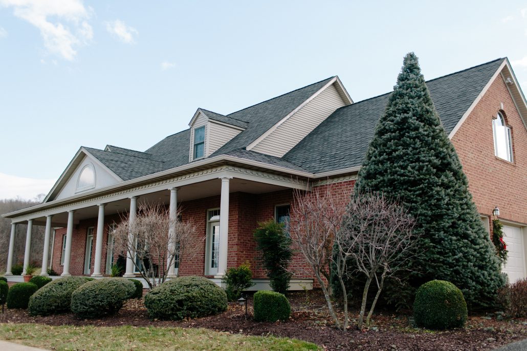 Brick Home With Shingle Roof & Gutters