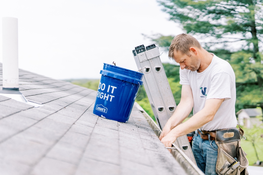 Valley Roofing & Exteriors worker cleaning gutters