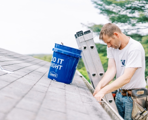 Valley Roofing & Exteriors worker cleaning gutters